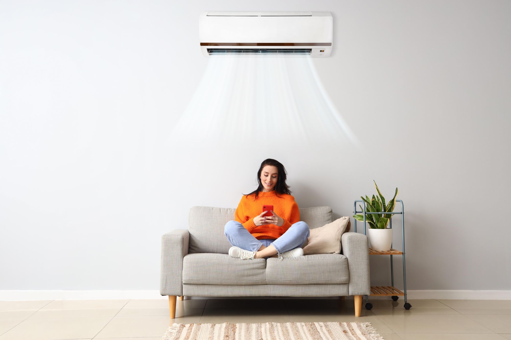 woman sitting under a functioning mini split air conditioner installed by DeSplinter 72 Degrees